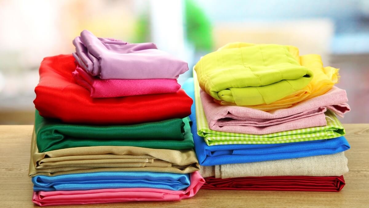 pilha de tecidos para costura sobre uma mesa