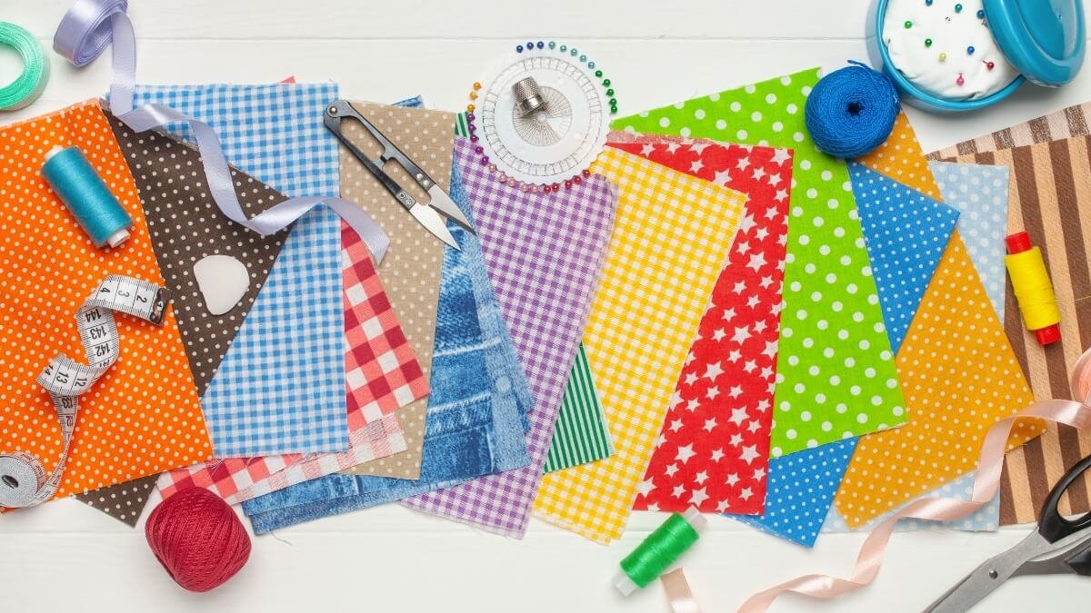Materiais essenciais para costura criativa para iniciantes sobre superfície clara.