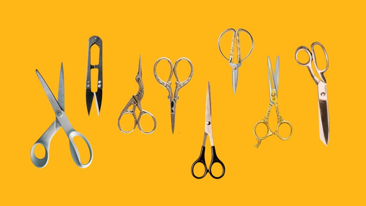 Tesouras de costura de diferentes modelos dispostas em superfície clara para demonstração.